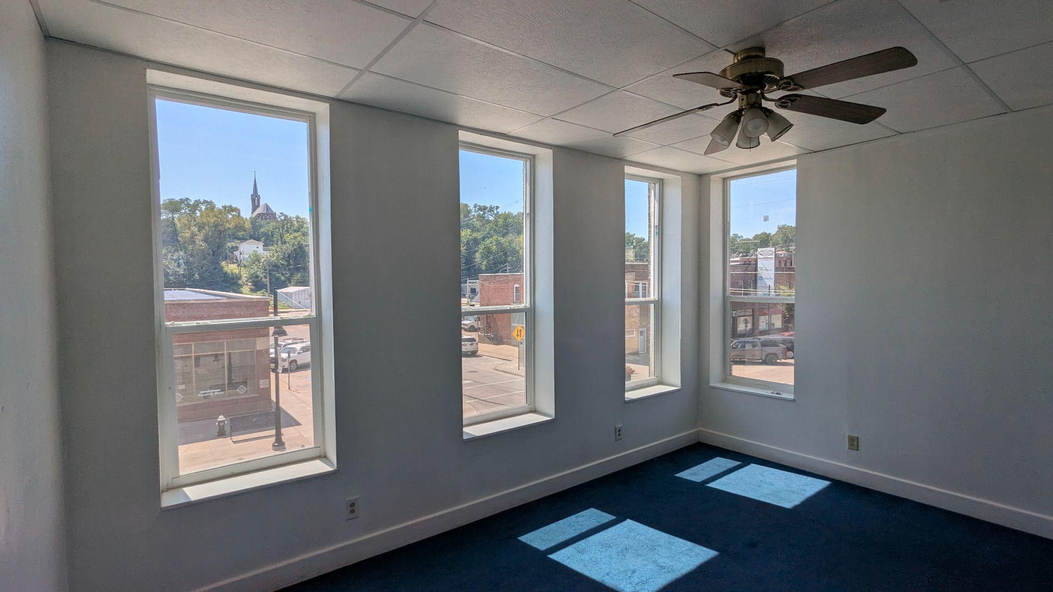 Upstairs apartment living room with tall windows