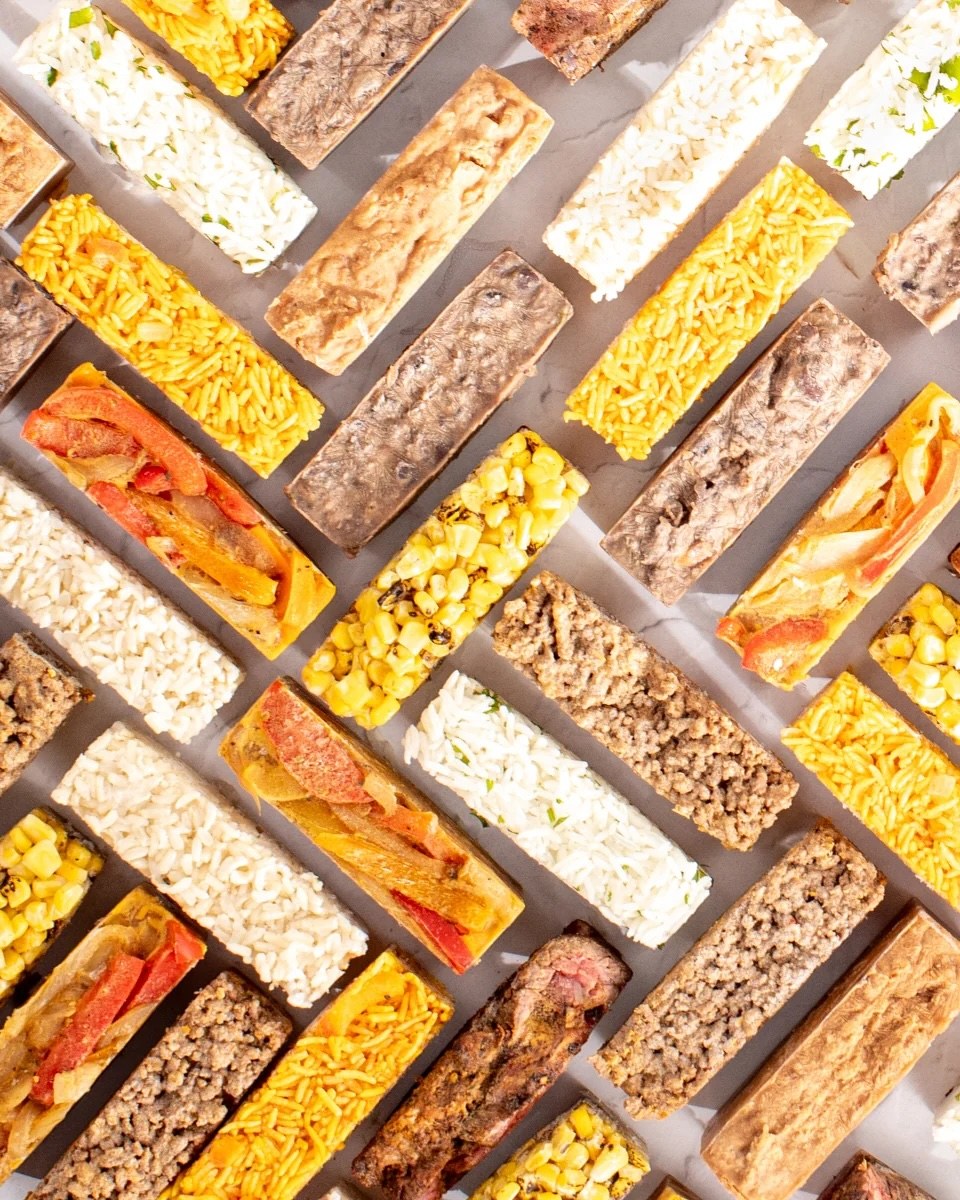 Frozen cubes of rice, corn, peppers, beans and meat laid out in rows