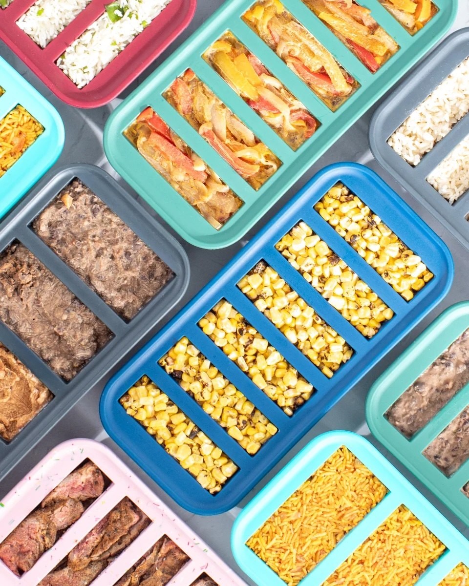 Rice, fajita vegetables, roasted corn and beans portioned into colored freezer trays